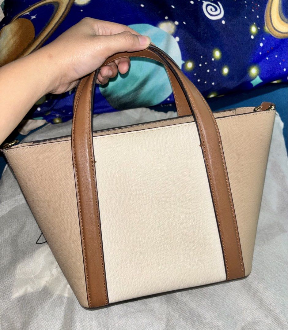 Michael Kors Bag (Category: Luxury Bags & Wallets) located in Marikina City. Submitted by littlespender (Listing ID 1460161159, Image 3). Description: - Stylish Michael Kors tote bag - Elegant beige and cream colorblock design - Genuine leather trim and handles - Includes a detachable crossbody strap for versatile wear - Accented with sophisticated gold hardware - Ample interior space for all your essentials - Ideal for everyday use and a perfect