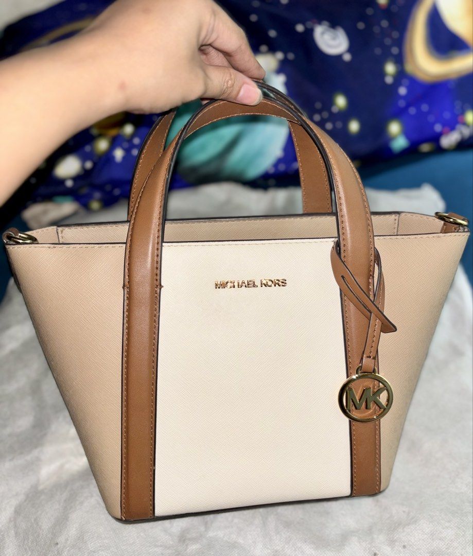 Michael Kors Bag (Category: Luxury Bags & Wallets) located in Marikina City. Submitted by littlespender (Listing ID 1460161159, Image 2). Description: - Stylish Michael Kors tote bag - Elegant beige and cream colorblock design - Genuine leather trim and handles - Includes a detachable crossbody strap for versatile wear - Accented with sophisticated gold hardware - Ample interior space for all your essentials - Ideal for everyday use and a perfect
