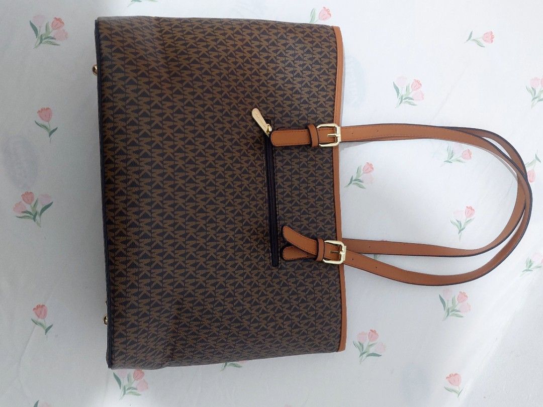 Michael Kors Monogram Tote Bag (Category: Shoulder Bags) located in Muntinlupa City. Submitted by arvie_07 (Listing ID 1460136252, Image 3). Description: - Authentic Michael Kors tote bag - Classic brown monogram print - Tan leather trim - Gold hardware details - Adjustable shoulder straps - Front zip pocket - Spacious interior for essentials - Ideal for everyday use.