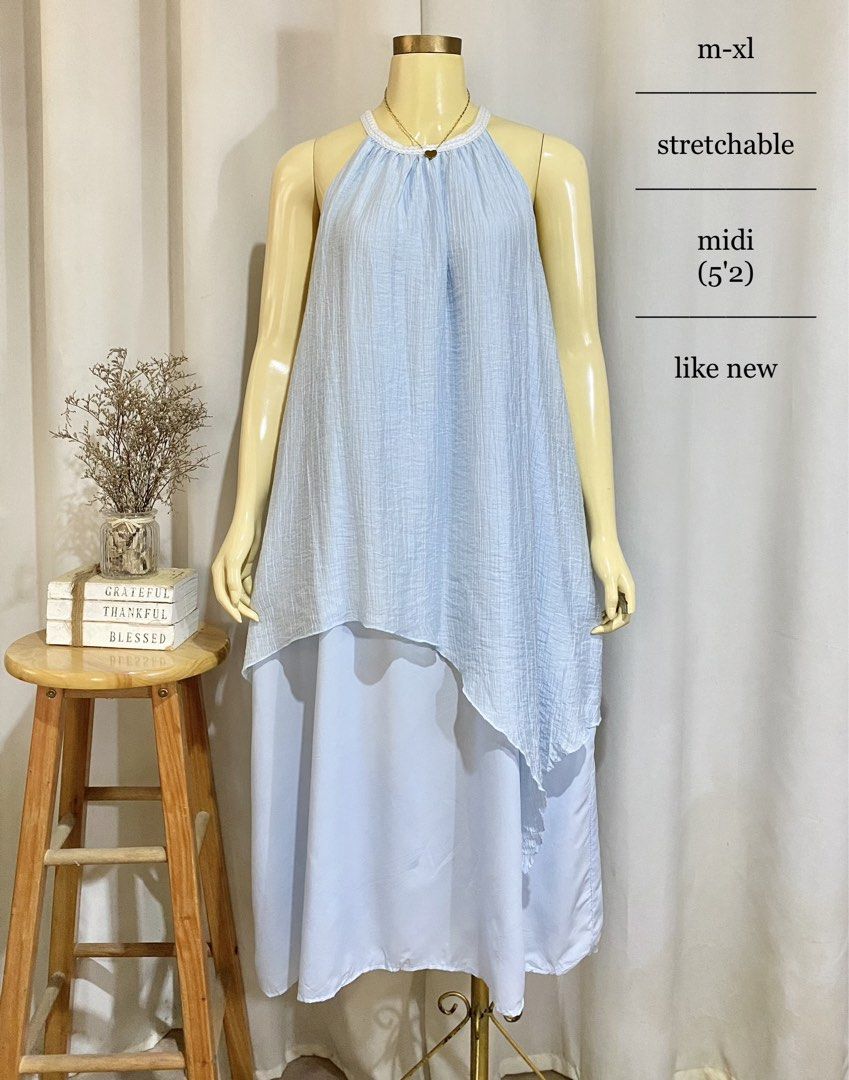 Midi Dress (Category: Dresses) located in Compostela. Submitted by iamjam.1213 (Listing ID 1460222869, Image 1). Description: • Color: Light pastel blue • Style: Halter-neck, sleeveless, layered, or two-piece illusion midi dress featuring a textured, crinkled top layer with an asymmetrical hem over a smooth, flowing inner layer • Size: M to XL (stretchable) • Length: Midi length (hits around mid-calf for a 5-foot-2-inch frame) • Condition: Like n
