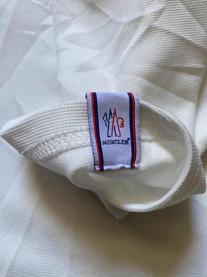 Moncler White Polo Shirt with Logo Patch (Category: Tshirts & Polo Shirts ) located in Zamboanga. Submitted by trippsnthrifts (Listing ID 1460256799, Image 3). Description: - Classic white Moncler polo shirt - Features iconic Moncler logo patch on sleeve - Buttonless placket with a classic collar - Comfortable and stylish design - Perfect for casual outings or as a layering piece.