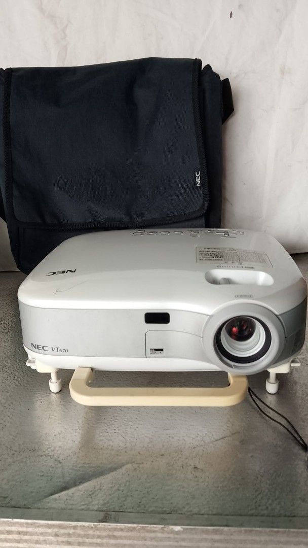 NEC VT670 Projector with Bag (Category: Projectors) located in Quezon City. Submitted by jpnvintageonline (Listing ID 1460268722, Image 1). Description: - NEC VT670 projector - Includes dark grey NEC carrying bag - Multiple input ports: S-Video, Audio, Video, Computer 1, Computer 2, Monitor Out, PC Control - Power switch and AC in located on the back - Ideal for presentations and home entertainment.
