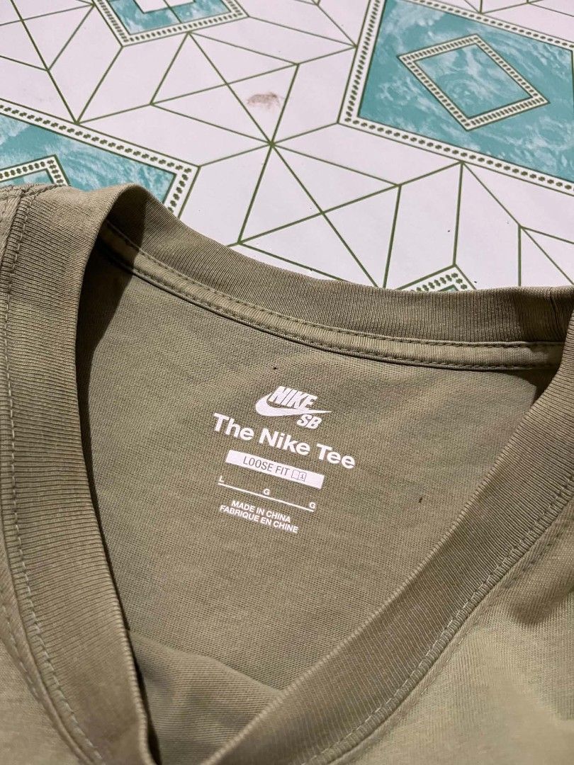 Nike SB Loose Fit Tee (Category: Tshirts & Polo Shirts ) located in Manila. Submitted by _lemornosnas02 (Listing ID 1460204424, Image 2). Description: - Olive green Nike SB t-shirt - Loose fit - Size Large - Features a graphic print on the front - Made in China - Ideal for casual wear.