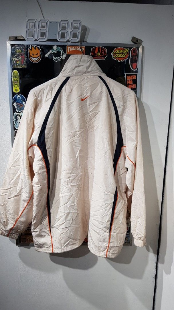 Nike Sports Windbreaker Jacket (Category: Coats, Jackets and Outerwear) located in Manila. Submitted by nice430 (Listing ID 1460225671, Image 2). Description: - Lightweight Nike windbreaker jacket - Cream color with navy and orange accents - Full zip front with stand-up collar - Ideal for layering or light protection - Nike Sports branding on sleeves - Easy to pack and carry.