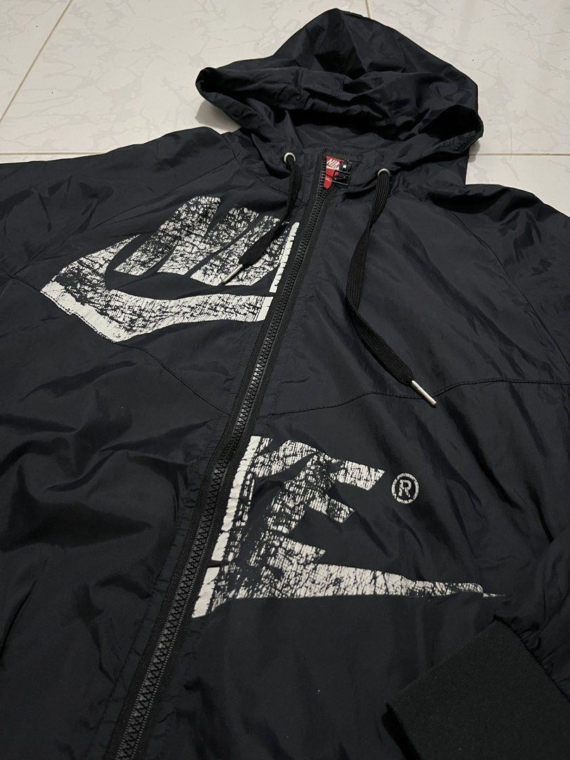 Nike Windbreaker Jacket (Category: Coats, Jackets and Outerwear) located in Urdaneta. Submitted by supremo_fi (Listing ID 1460121212, Image 2). Description: - 2XL on tag but fits slimmer sizes - Navy Blue Nike windbreaker jacket - Features large distressed Nike graphic on front - Smaller Nike graphic on side - Hooded with full zip closure - Elasticated cuffs and hem - Ideal for everyday wear or sports activities.