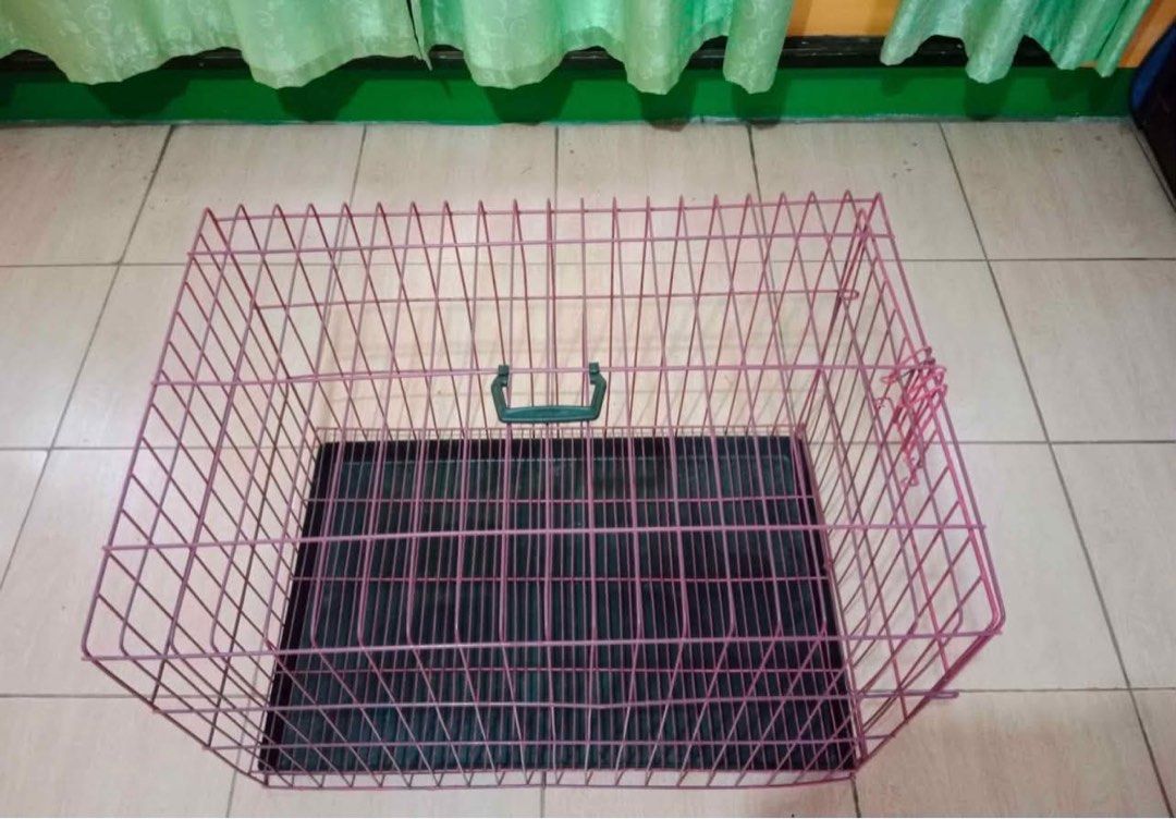 Pink Wire Pet Cage with Tray (Category: Homes & Other Pet Accessories) located in General Luna. Submitted by gentlelion_c5f45d (Listing ID 1460117955, Image 1). Description: - Pink wire pet cage - Includes black plastic tray - Front door opens outwards - Suitable for small to medium pets - Easy to set up and fold for storage - Tray slides out for convenient cleaning.