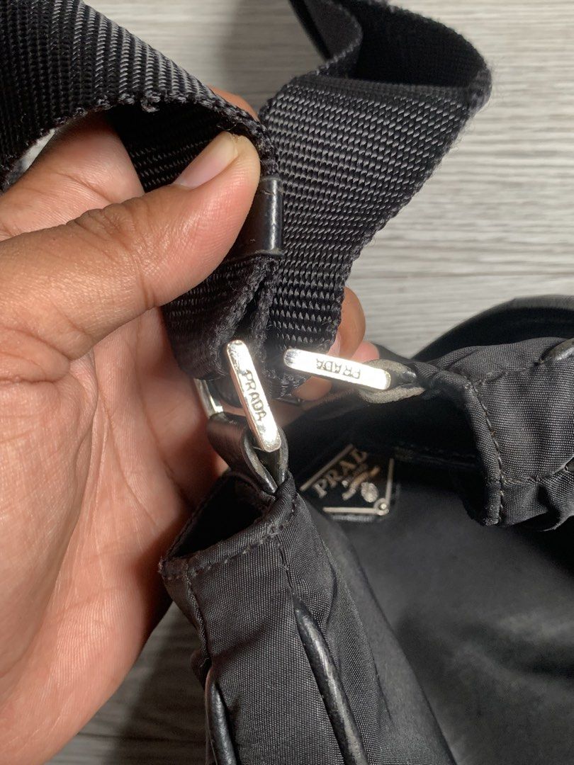 Prada Nylon Crossbody Bag (Category: Luxury Bags & Wallets) located in Pozorrubio. Submitted by plco. (Listing ID 1460113332, Image 3). Description: Prada nylon crossbody bag Width: 8.5 inches Height: 7.5 inches missing white tag broken inner zip minor scuff no other issues.