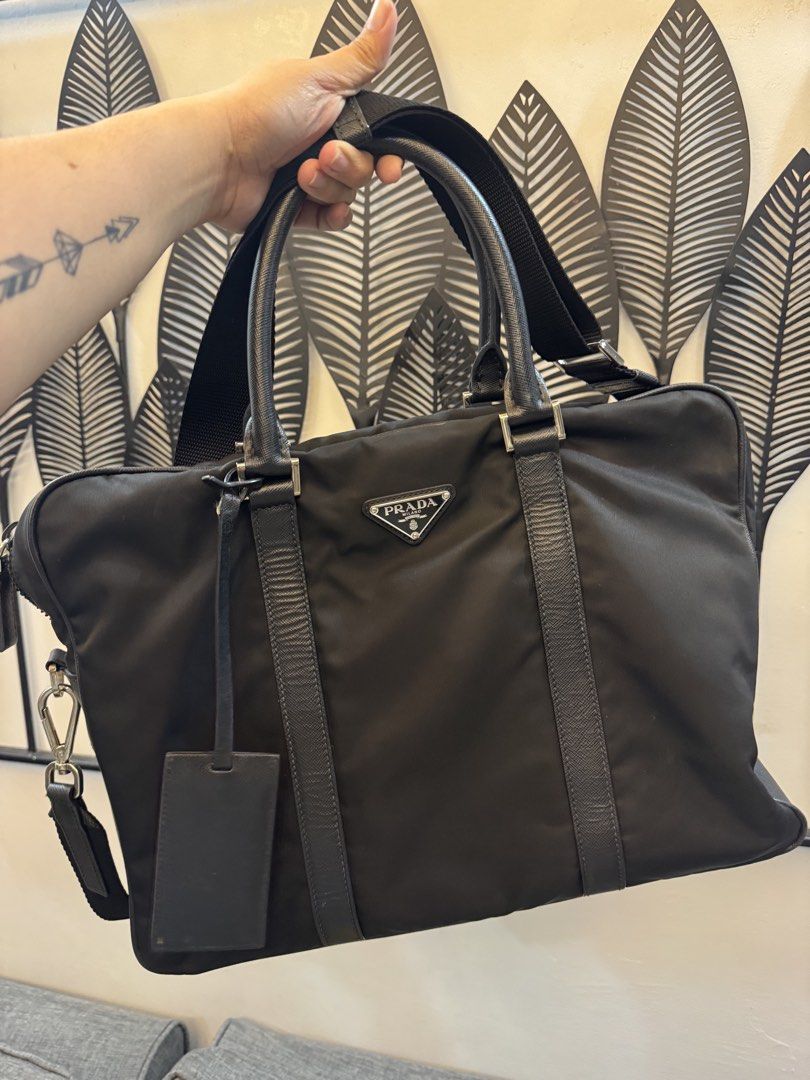 Prada Nylon Laptop Bag (Category: Luxury Bags & Wallets) located in Dasmarinas. Submitted by mommymitchy (Listing ID 1460282290, Image 1). Description: - Authentic Prada laptop bag - Color: Black - Material: Nylon with leather trim - Features: Top handles, detachable shoulder strap - Includes: Leather luggage tag - Perfect for: Travel or everyday use - Interior: Spacious Minimal wear and tear interior. But very smooth exterior. .