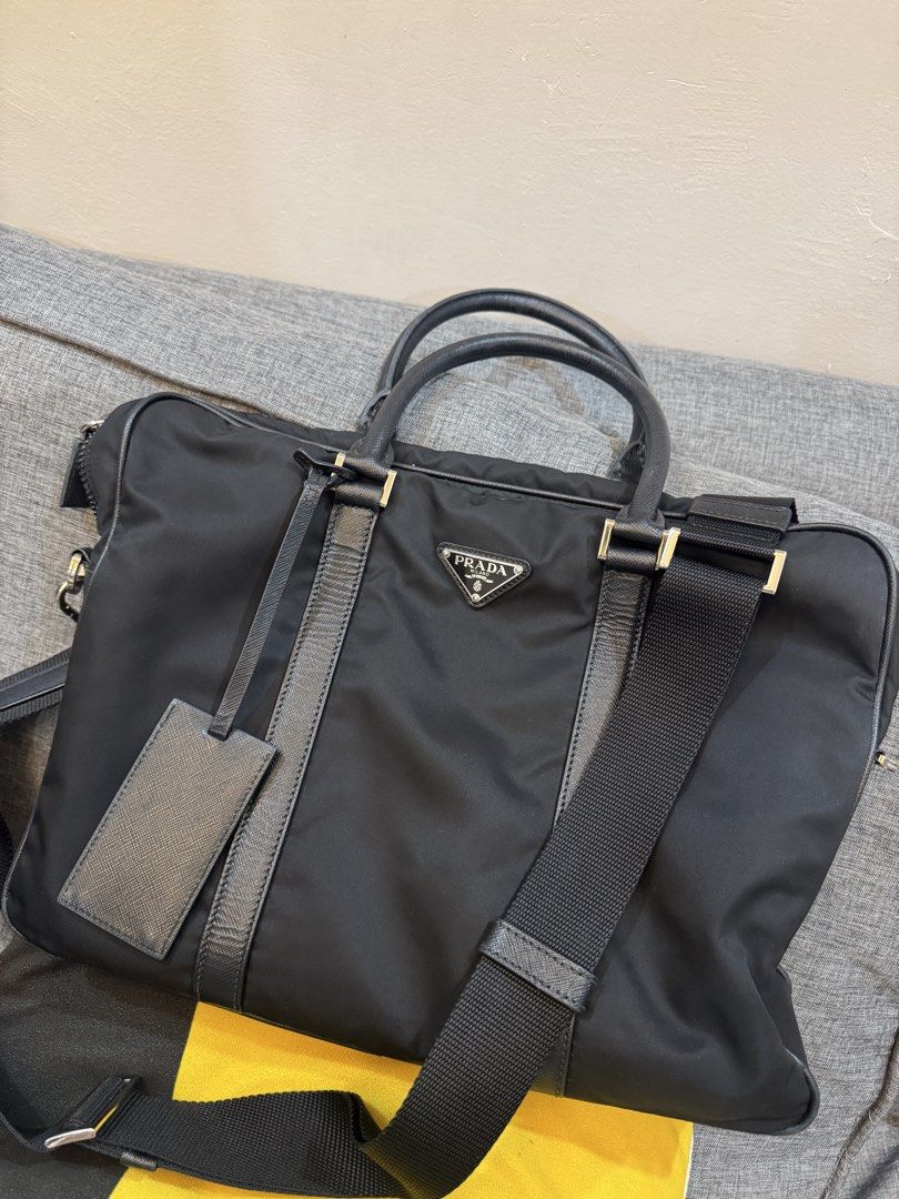 Prada Nylon Laptop Bag (Category: Luxury Bags & Wallets) located in Dasmarinas. Submitted by mommymitchy (Listing ID 1460282290, Image 3). Description: - Authentic Prada laptop bag - Color: Black - Material: Nylon with leather trim - Features: Top handles, detachable shoulder strap - Includes: Leather luggage tag - Perfect for: Travel or everyday use - Interior: Spacious Minimal wear and tear interior. But very smooth exterior. .