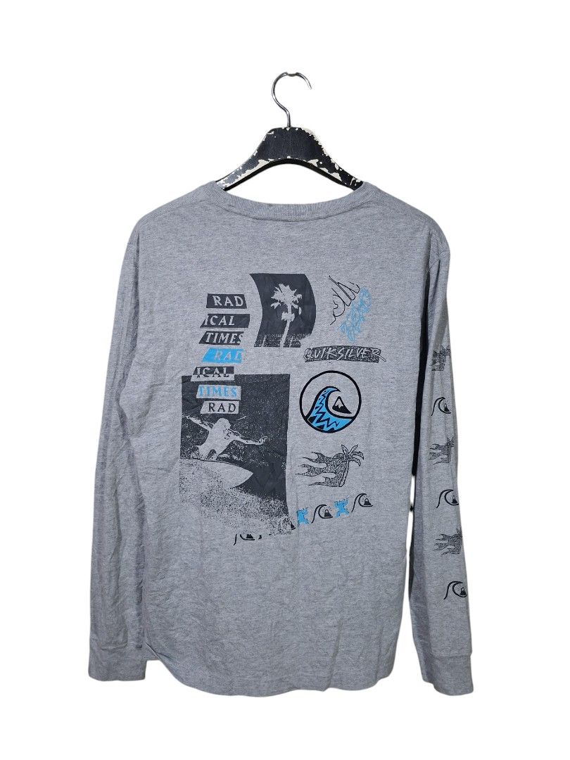 Quiksilver (Category: Tshirts & Polo Shirts ) located in San Juan (Cabalian). Submitted by ec8thrift (Listing ID 1460236632, Image 3). Description: - Quiksilver grey long sleeve t-shirt - Features a striking graphic print on the back with waves, palm trees, and surfing motifs - Includes smaller graphics on the sleeves - Made from comfortable, breathable cotton material - Ideal for casual outings or beach-ready style.