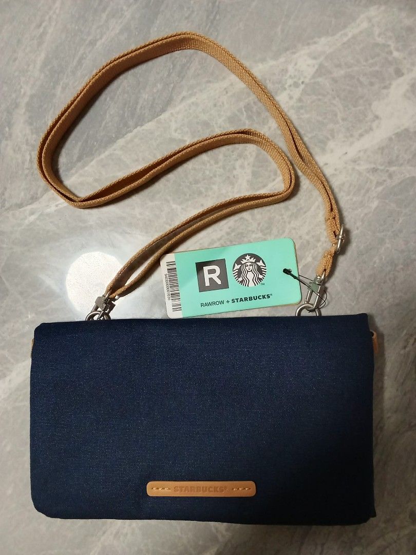 RAWROW + Starbucks Collaboration Pouch Bag with Strap (Category: Purses & Pouches) located in Manila. Submitted by cosmiccloud-9236 (Listing ID 1460209749, Image 1). Description: - Authentic RAWROW x Starbucks collaboration pouch bag - Color: Dark blue canvas - Includes a tan adjustable strap - Features iconic Starbucks logo and RAWROW branding - Ideal for carrying your daily essentials - Brand new with tag still attached.