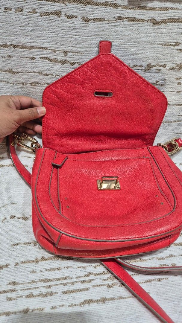 Red Leather Crossbody Bag with Gold Hardware (Category: Cross-body Bags) located in Quezon City. Submitted by prelovedluxury21 (Listing ID 1460138983, Image 2). Description: - Genuine red leather crossbody bag - Stylish buckle detail on the front flap - Elegant gold hardware accents - Convenient zipper pocket on the back - Adjustable strap for comfortable wear - Interior includes a main compartment and a smaller pocket - Ideal for everyday use an