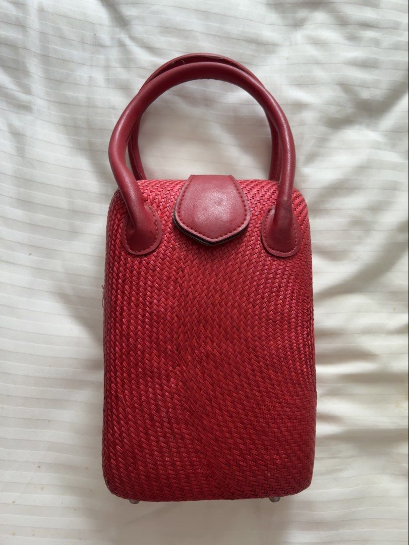 Red Woven Handbag with Leather Accents (Category: Luxury Bags & Wallets) located in Pasig City. Submitted by jenscloset86 (Listing ID 1460160738, Image 1). Description: Measurement: Height: 10” Length: 6.5” Width: 4.5” Strap: 18” - Adorable red woven handbag - Genuine leather handles - Secure leather clasp closure - Tight, textured weave - Small and compact size, ideal for essentials - Adds a vibrant pop of color to any outfit - Pre-loved and rea