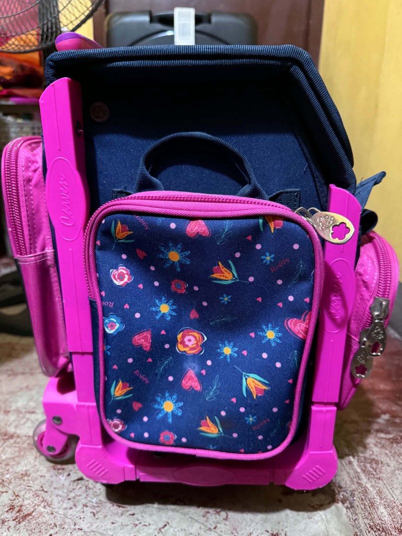 Robby Planet Pink Blue Rolling Backpack with Wheels (Category: Babies & Kids Fashion) located in Manila. Submitted by totrafort_charot (Listing ID 1460262064, Image 3). Description: - Adorable rolling backpack for kids - Fun floral and heart pattern on front pocket - Stylish navy blue and bright pink colors - Retractable handle and wheels for easy carrying - Spacious main compartment for essentials - Convenient side pockets for extra storage - Id