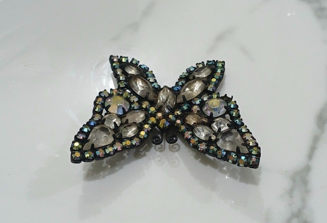 Sparkly Butterfly Brooch Rhinestone Pin (Category: Brooches) located in Bulacan. Submitted by honhonliz (Listing ID 1440600793, Image 2). Description: Sparkling butterfly brooch decorated with faceted rhinestones and iridescent accents that shimmer beautifully under light. A statement accessory perfect for coats, dresses, or bags. Elegant butterfly design Multi-faceted rhinestones with rainbow shimmer Size: 5 cm x 5 cm Preloved condition; please 