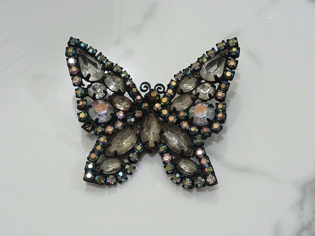 Sparkly Butterfly Brooch Rhinestone Pin (Category: Brooches) located in Bulacan. Submitted by honhonliz (Listing ID 1440600793, Image 1). Description: Sparkling butterfly brooch decorated with faceted rhinestones and iridescent accents that shimmer beautifully under light. A statement accessory perfect for coats, dresses, or bags. Elegant butterfly design Multi-faceted rhinestones with rainbow shimmer Size: 5 cm x 5 cm Preloved condition; please 