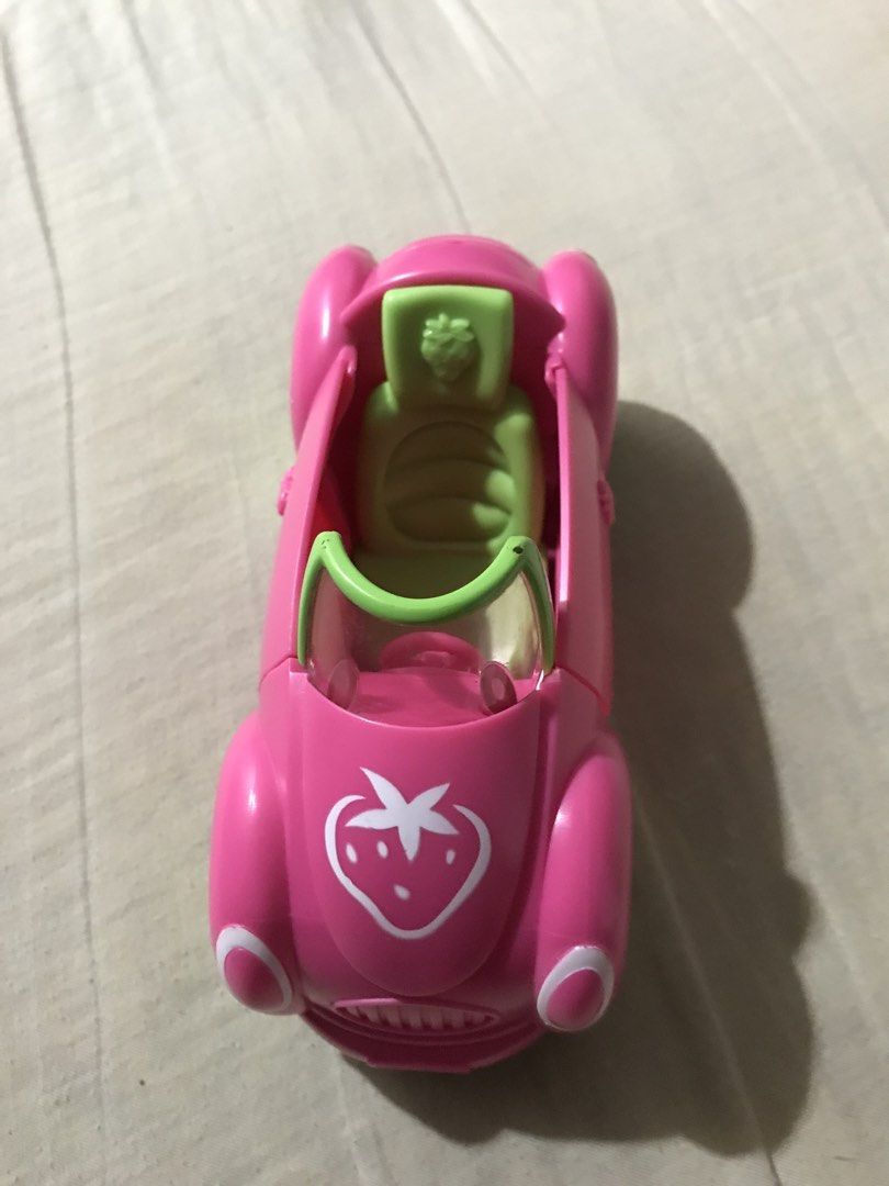 Strawberry Shortcake Car (Category: Kids Toys) located in Cavite. Submitted by lizetteag01493 (Listing ID 1460212033, Image 2). Description: - Strawberry Shortcake adorable pink toy car - Bright green wheels with charming white flower hubcaps - Approximately 6 inches in length (measured with tape measure) - Encourages imaginative play - Ideal size for small hands.