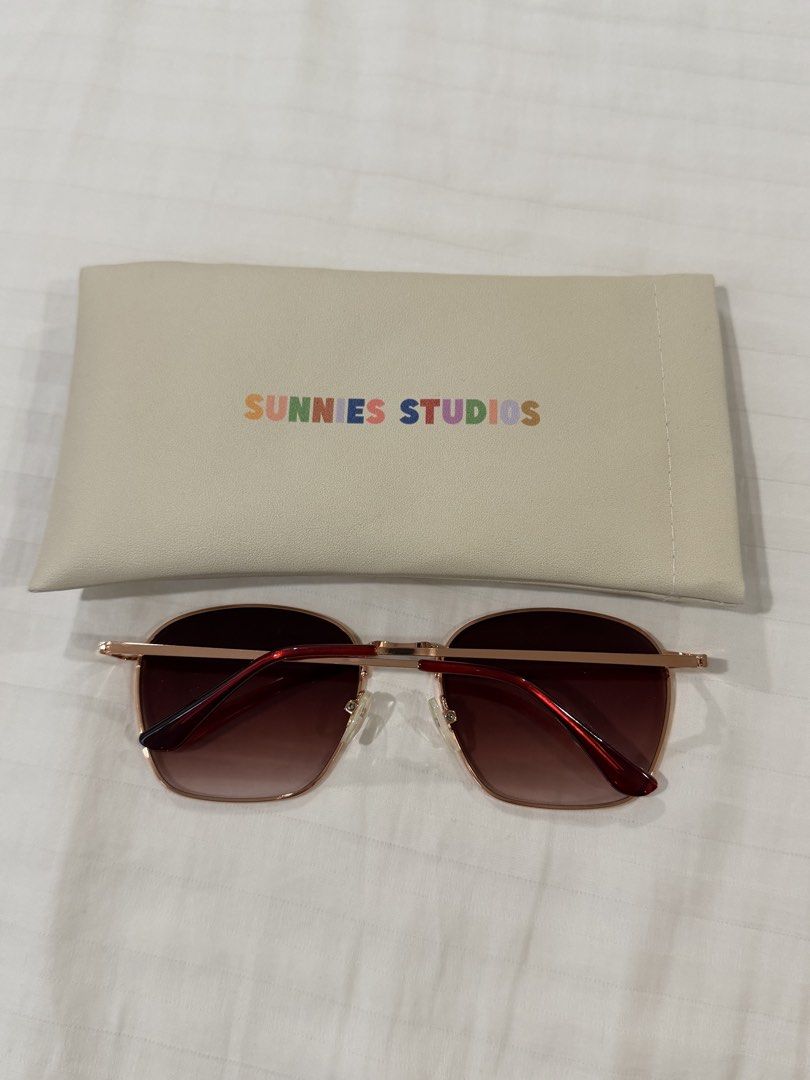 SUNNIES STUDIOS Rose Gold Sunglasses with Case (Category: Sunglasses & Eyewear) located in Quezon City. Submitted by myriadtrinkets (Listing ID 1460176262, Image 2). Description: - Rose gold frame sunglasses - Brown gradient lenses - Comes with a cream colored pouch - Pouch features rainbow SUNNIES STUDIOS logo - Ideal for sunny days out.