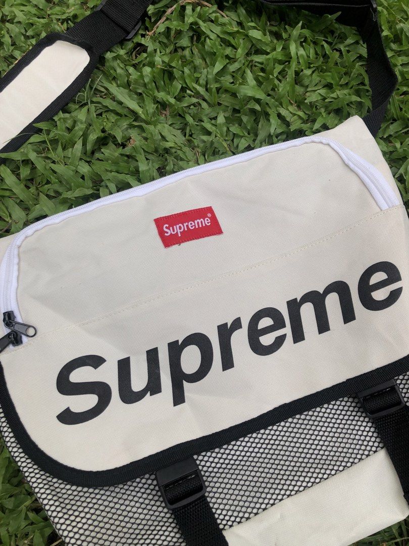 Supreme Messenger Bag White (Category: Luxury Bags & Wallets) located in Kabasalan. Submitted by hamugaway (Listing ID 1460196208, Image 2). Description: - White Supreme messenger bag - Large main compartment with zip closure - Front flap featuring a prominent Supreme logo - Mesh detailing on the sides for added style and ventilation - Adjustable shoulder strap with comfortable padding - Ideal for everyday use with ample storage space - Missing w