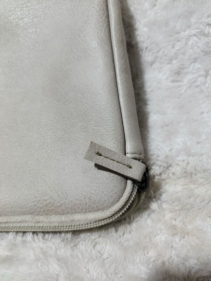 THIS IS GROUND Pouch (Category: Purses & Pouches) located in San Leonardo. Submitted by burgossanleonardo.12345 (Listing ID 1460281123, Image 3). Description: - Brand: THIS IS GROUND - Color: Light Grey - Closure: Zipper - Interior: Soft lining with pockets - Size: Approximately 7 inches x 5 inches - Use: Ideal for organizing small items - Condition: Clean and ready for a new owner.