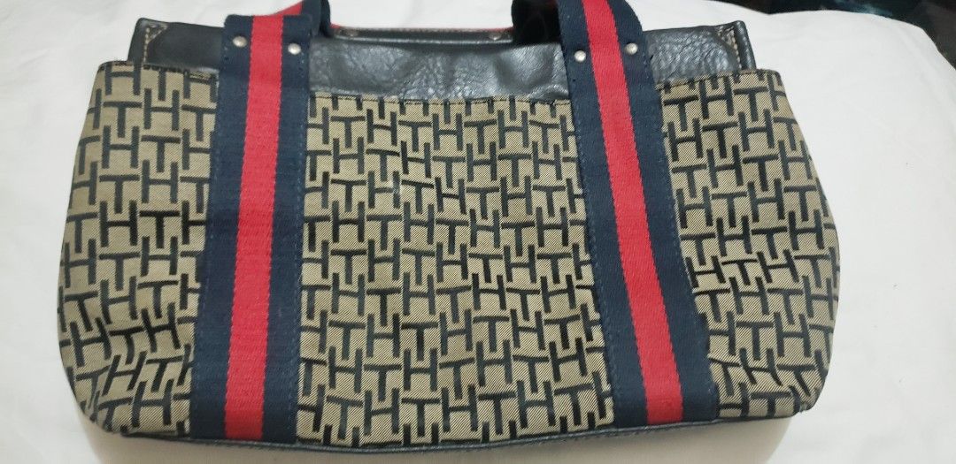 Tommy Hilfiger Monogram Canvas & Leather Handbag (Category: Luxury Bags & Wallets) located in Marikina City. Submitted by racoon143 (Listing ID 1460282038, Image 2). Description: - Authentic Tommy Hilfiger handbag - Signature TH monogram pattern on canvas - Red and blue stripe details on handles - Leather accents - Secure snap closure with Tommy Hilfiger logo - Classic and versatile for everyday use - Please check photos for detailed condition.