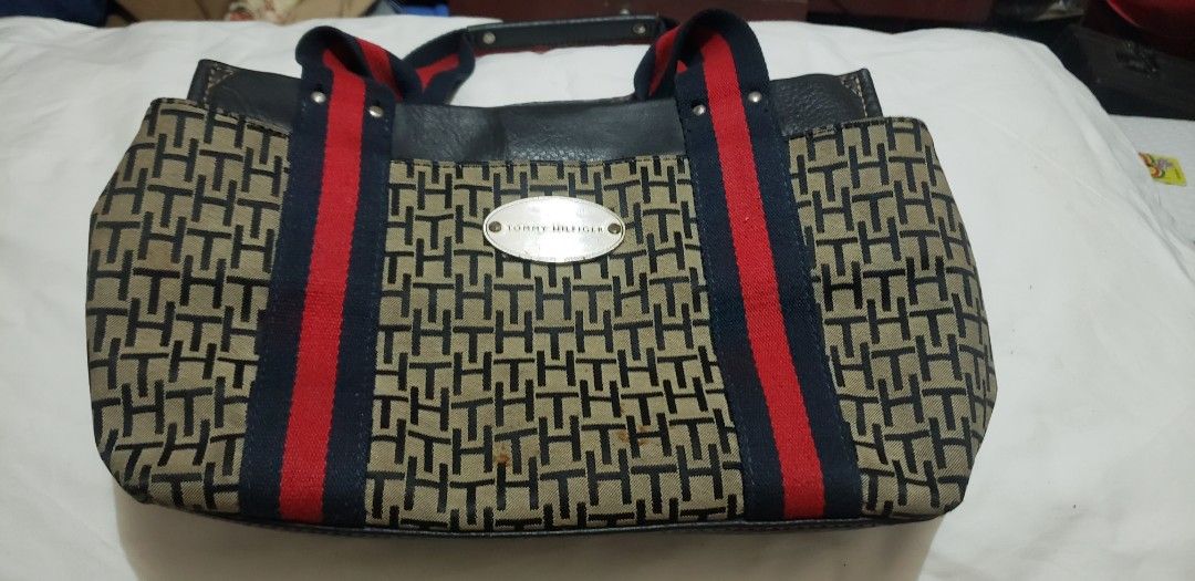 Tommy Hilfiger Monogram Canvas & Leather Handbag (Category: Luxury Bags & Wallets) located in Marikina City. Submitted by racoon143 (Listing ID 1460282038, Image 1). Description: - Authentic Tommy Hilfiger handbag - Signature TH monogram pattern on canvas - Red and blue stripe details on handles - Leather accents - Secure snap closure with Tommy Hilfiger logo - Classic and versatile for everyday use - Please check photos for detailed condition.