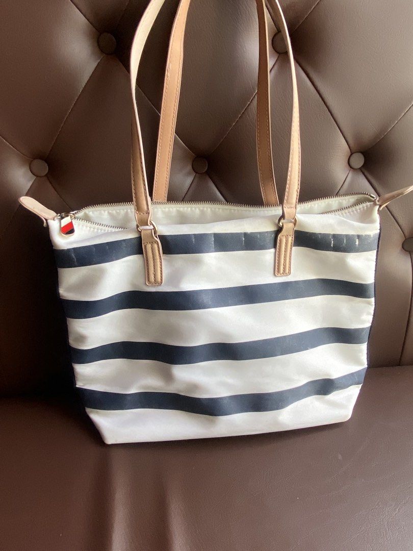 Tommy Hilfiger Striped Tote Bag (Category: Tote Bags) located in Zamboanga. Submitted by trippsnthrifts (Listing ID 1460257757, Image 2). Description: - Classic Tommy Hilfiger tote bag - Black and white stripe design - Tan leather handles - Multiple interior compartments for organization - Secure zipper closure - Ideal for everyday use or travel.