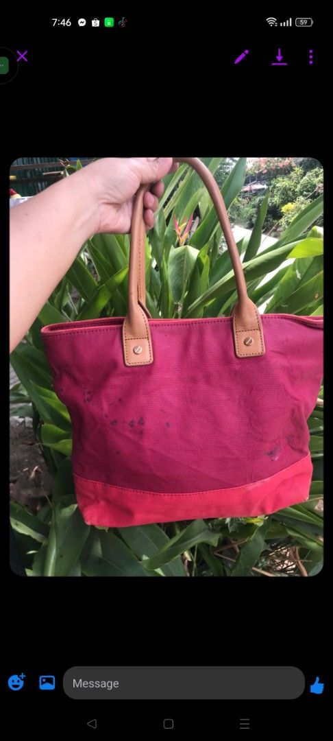 Tory Burch Canvas Tote Bag - Pink (Category: Tote Bags) located in Midsayap. Submitted by purse_gedo (Listing ID 1460304400, Image 2). Description: - Pink canvas tote bag - Tan leather handles - Features Tory Burch logo on front - Interior zippered pocket and slip pockets - Exterior canvas has marks and stains, particularly on the front - Still a functional and stylish bag.