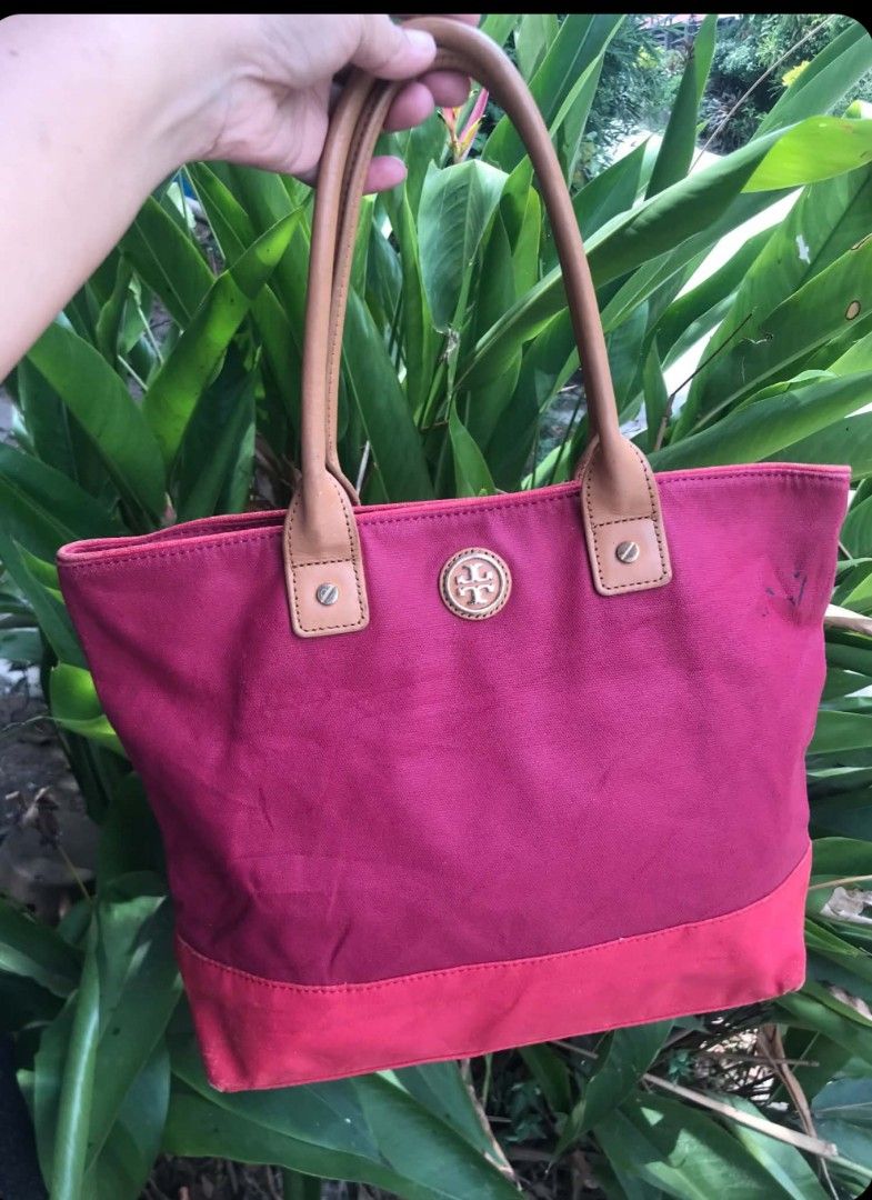 Tory Burch Canvas Tote Bag - Pink (Category: Tote Bags) located in Midsayap. Submitted by purse_gedo (Listing ID 1460304400, Image 1). Description: - Pink canvas tote bag - Tan leather handles - Features Tory Burch logo on front - Interior zippered pocket and slip pockets - Exterior canvas has marks and stains, particularly on the front - Still a functional and stylish bag.