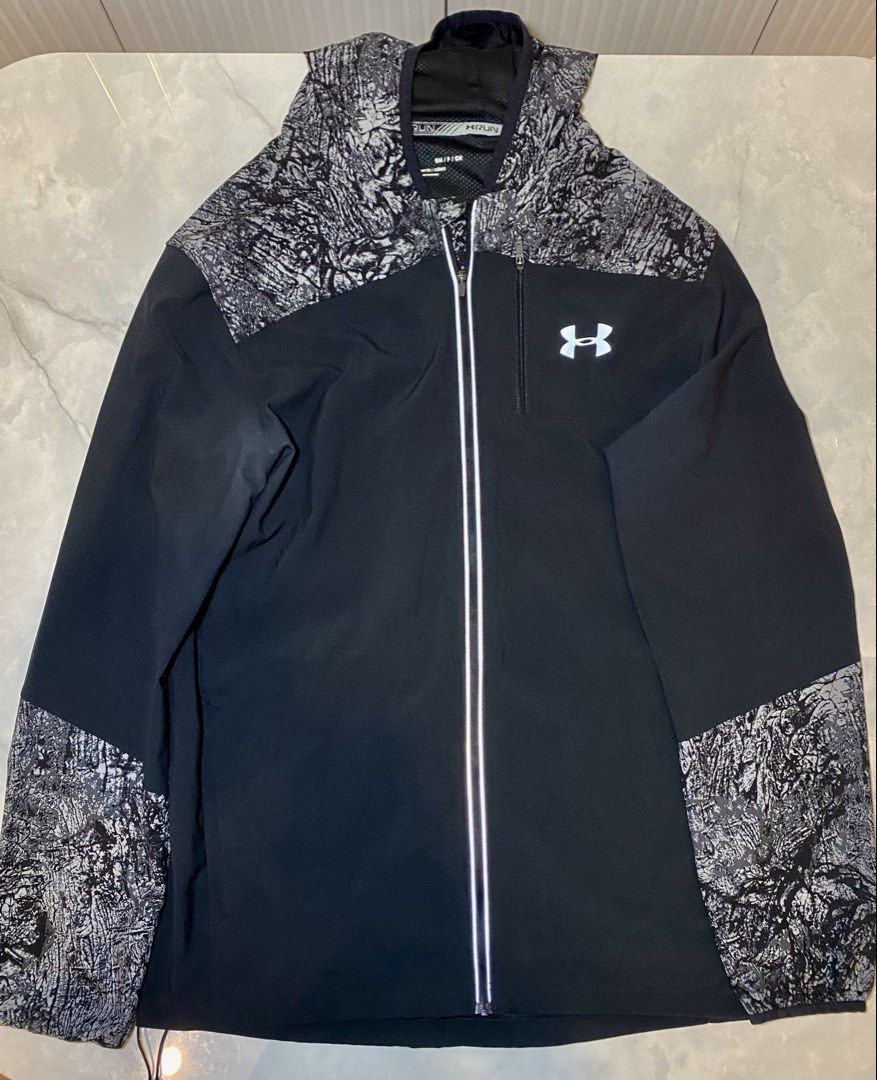 Under Armour Run Fitted Jacket SM/P/CH (Category: Coats, Jackets and Outerwear) located in Manila. Submitted by sebthrift (Listing ID 1460128851, Image 1). Description: - Under Armour running jacket - Color: Black with grey abstract pattern on shoulders, sleeves, and hood - Features: Zippered chest pocket, reflective details on front zipper - Origin: Made in the Philippines - Size: SM/P/CH.