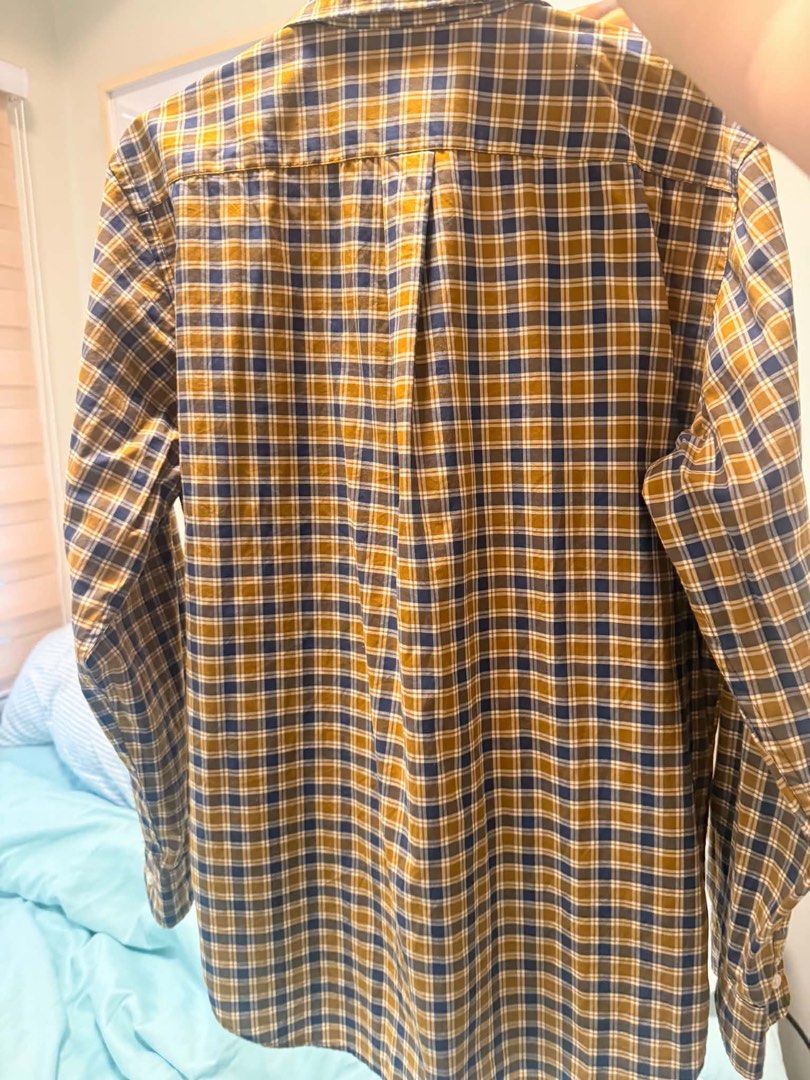 Uniqlo Long Sleeve Button Down Shirt (Category: Tshirts & Polo Shirts ) located in Mandaluyong City. Submitted by danee. (Listing ID 1460216180, Image 2). Description: - Classic plaid shirt from Uniqlo - Features brown, blue, and white checks - Button-down collar - Long sleeves - Ideal for casual or smart-casual outfits - Excellent for layering.