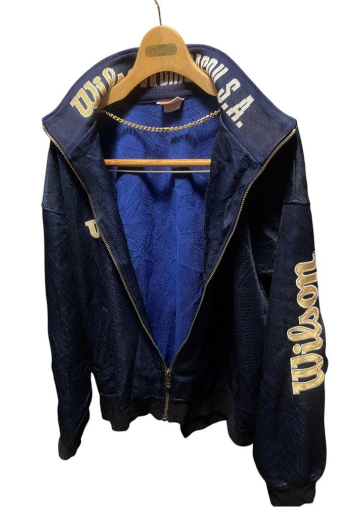 Vintage Wilson Chicago USA Track Jacket (Category: Coats, Jackets and Outerwear) located in San Pedro. Submitted by lifebeginsaftercoff33 (Listing ID 1460207109, Image 2). Description: - Vintage Wilson track jacket - Can be unisex - Navy blue with Big gold embroidered logo (Sleeve) - 'Wilson Chicago U.S.A.' embroidered on collar - Zip-up front with pockets - Blue fabric lining - Ideal for casual wear or sports - Dimes: 25 x 25 in.