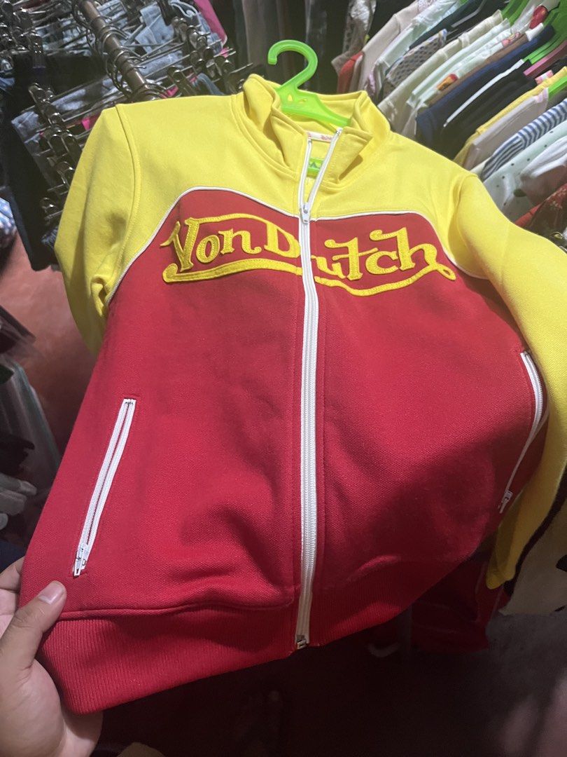 Von Dutch Track Jacket Red Yellow Size Small (Category: Coats, Jackets and Outerwear) located in Tabuk. Submitted by collectors_thrift_shop (Listing ID 1460120019, Image 1). Description: - Classic red and yellow Von Dutch track jacket - Features iconic Von Dutch logo across the chest - Zipper closure with convenient side pockets - Size: Small - Proudly American made.