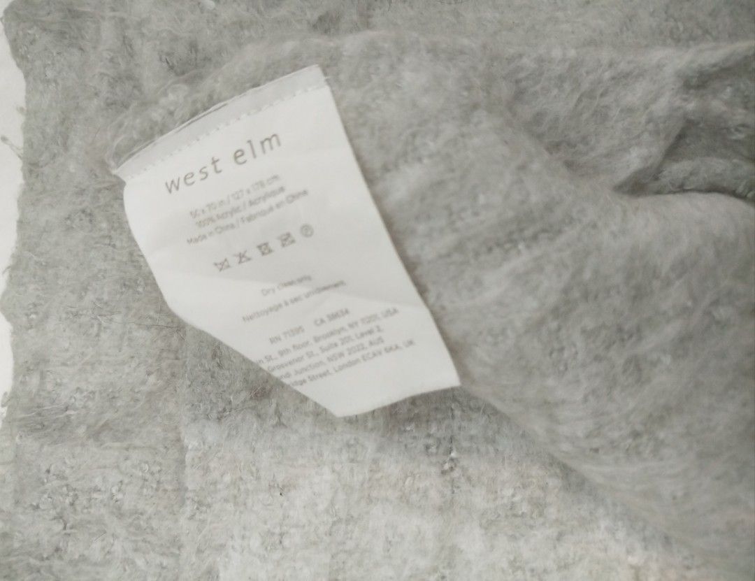 West Elm Grey Textured Throw Blanket with Fringe (Category: Bedding & Towels) located in Imus. Submitted by stop_shop7 (Listing ID 1460198120, Image 2). Description: - Cozy textured throw blanket from West Elm - Soft grey color with fringe details - Made from 100% acrylic - Dimensions: 50 x 70 inches - Perfect for adding warmth and style to your sofa or bed.