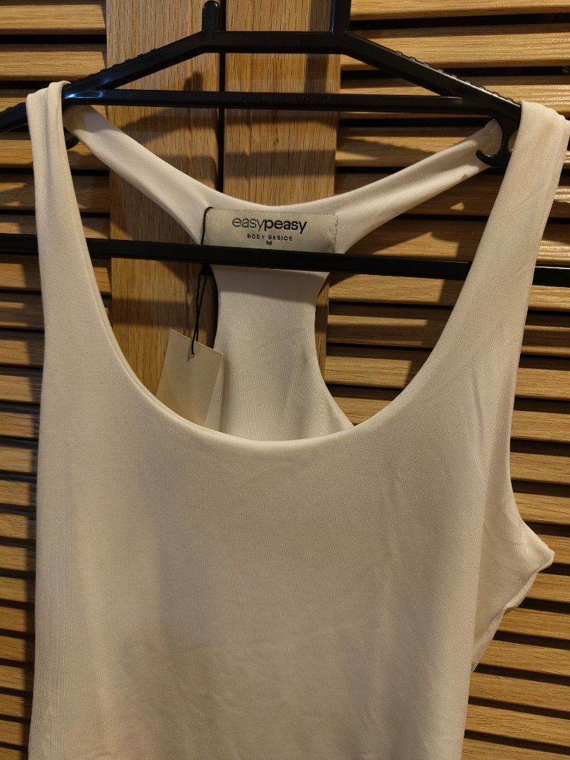 White Bodysuit - Brand New (Category: Sleeveless) located in Makati City. Submitted by kfcalderon926 (Listing ID 1460210659, Image 2). Description: brand: easy peasy size medium white racerback bodysuit never worn Rfs: decluttering MOP: BPI/Gcash/ Gotyme delivery: via Grab or Lalamove ONLY. sf c/o. buyer Location: Makati.