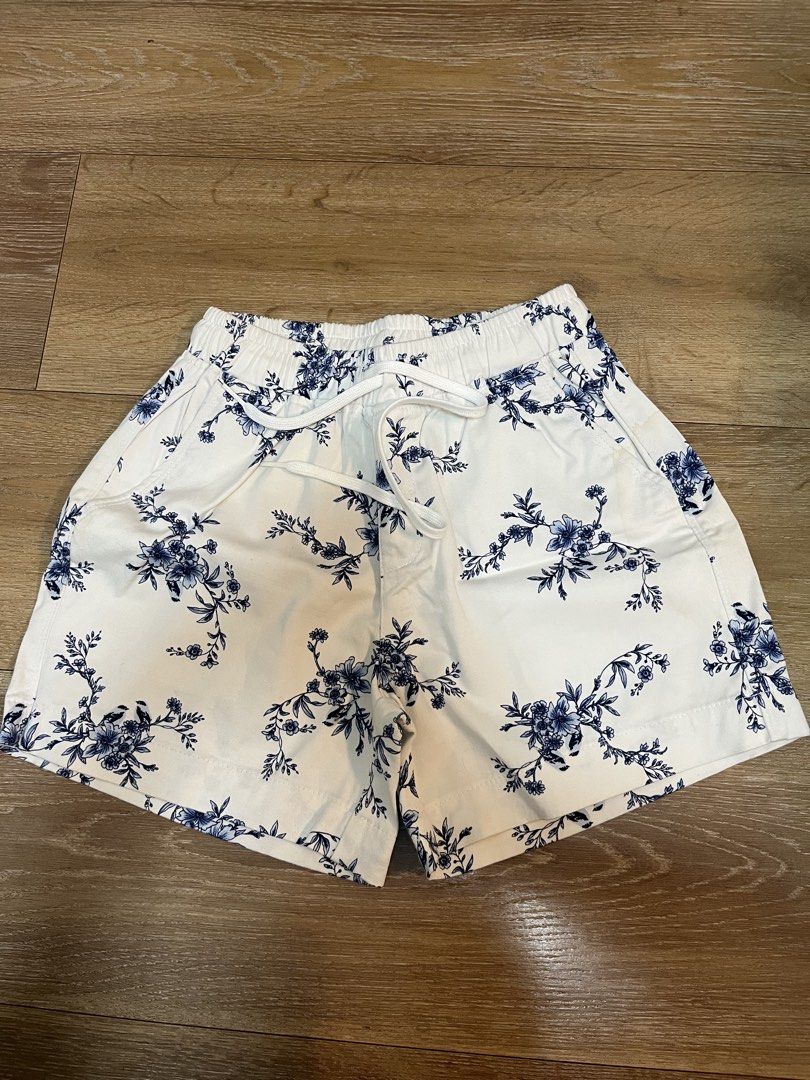 White Floral Shorts with Drawstring Waist (Category: Shorts) located in Pasig City. Submitted by d_cluttered (Listing ID 1460243824, Image 1). Description: - Cute white shorts with a charming blue floral print. - Comfortable elastic waistband with an adjustable drawstring. - Features convenient pockets on both the front and back. - Note: There are a couple of small, faint marks on the front pocket area. - Ideal for everyday casual wear or relaxin