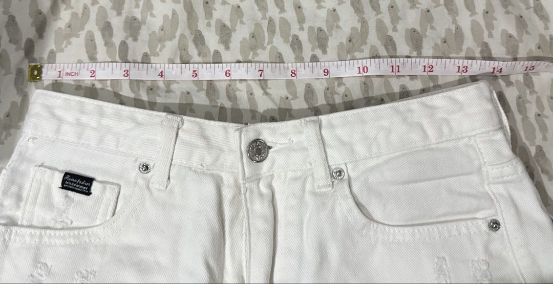 White Ripped Denim Shorts (Category: Shorts) located in Cebu City. Submitted by dianne.143 (Listing ID 1460128474, Image 3). Description: - High-waisted white denim shorts - Distressed rips and frayed hem - Button and zip closure - Classic five-pocket design - Ideal for casual wear - Versatile for pairing with any top.