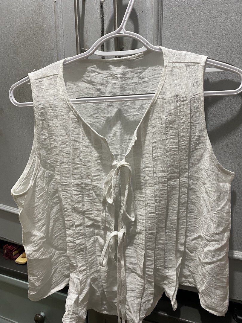 White Sleeveless Tie-Front Top Size M (Category: Sleeveless) located in Manila. Submitted by glads_closet (Listing ID 1460191974, Image 1). Description: White sleeveless top. Has a tie-front detail. Vertical textured pleats down the front. Lightweight fabric. Great for layering or wearing on its own. Easy to style..