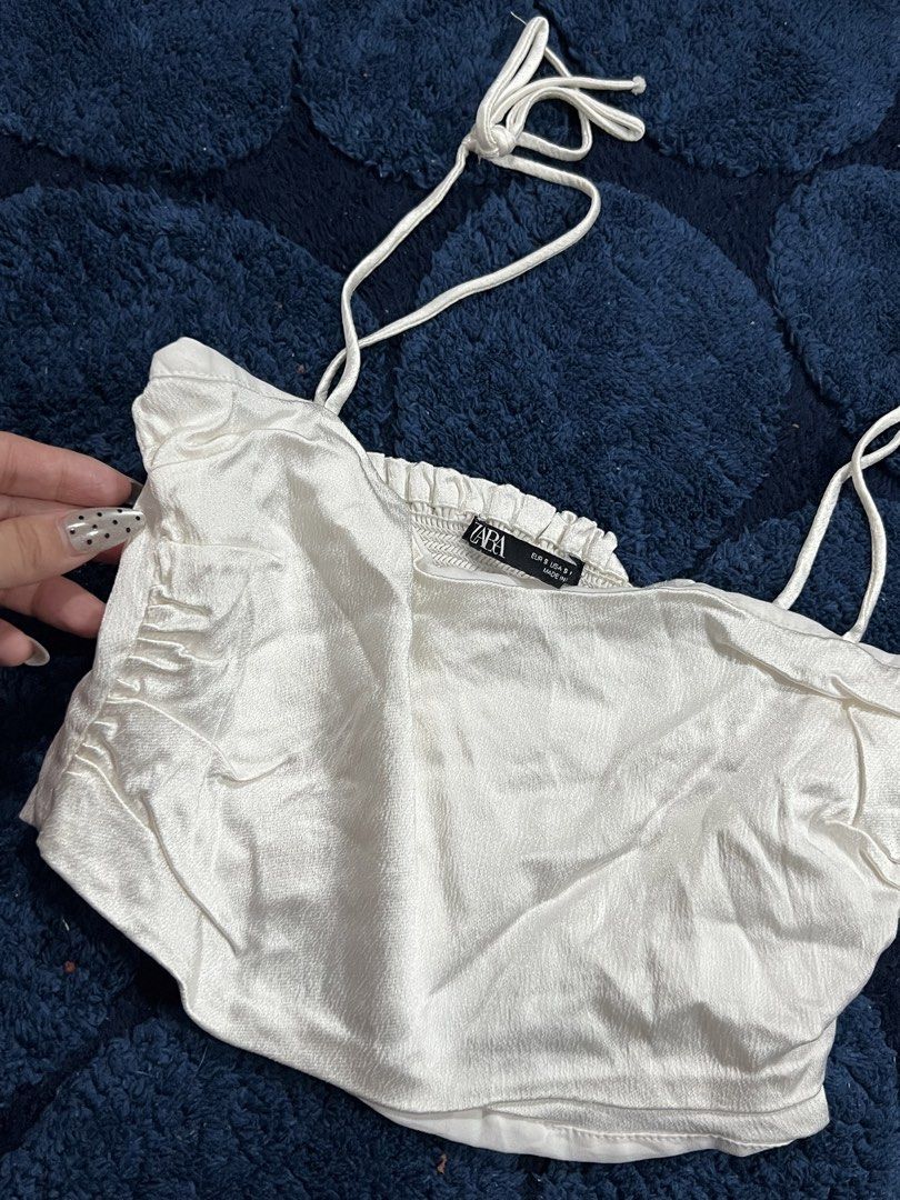 Zara White Ruched Tie Strap Crop Top (Category: Sleeveless) located in Manila. Submitted by camieday04 (Listing ID 1460150107, Image 2). Description: - Zara white ruched crop top - Features tie straps - Gathered bust detail - Perfect for pairing with high-waisted bottoms - Ideal for night outs or casual day looks - Comfortable and stylish.