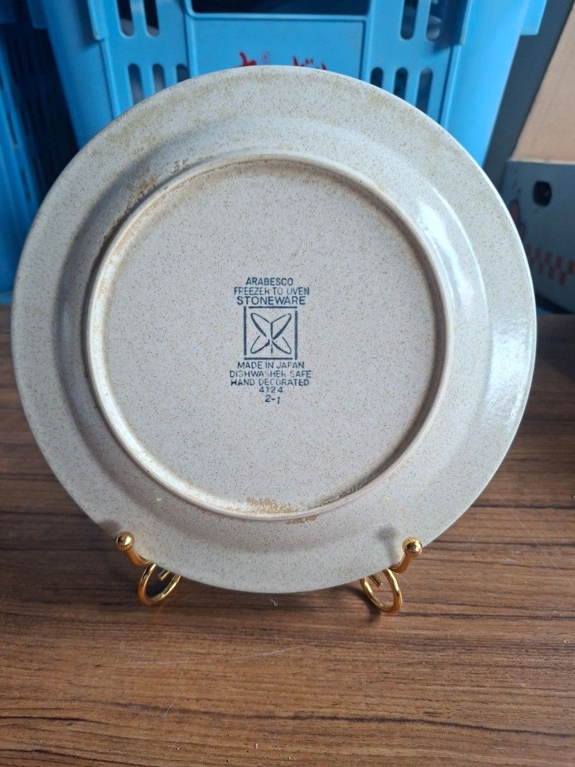 1970s Arabesco Stoneware Plate (Category: Dinnerware & Cutlery) located in Consolacion. Submitted by luxekerei (Listing ID 1460373161, Image 2). Description: - vintage 1970s Japanese stoneware plate featuring a speckled beige finish, a bold orange rim, and a detailed central brown-and-rust floral medallion..