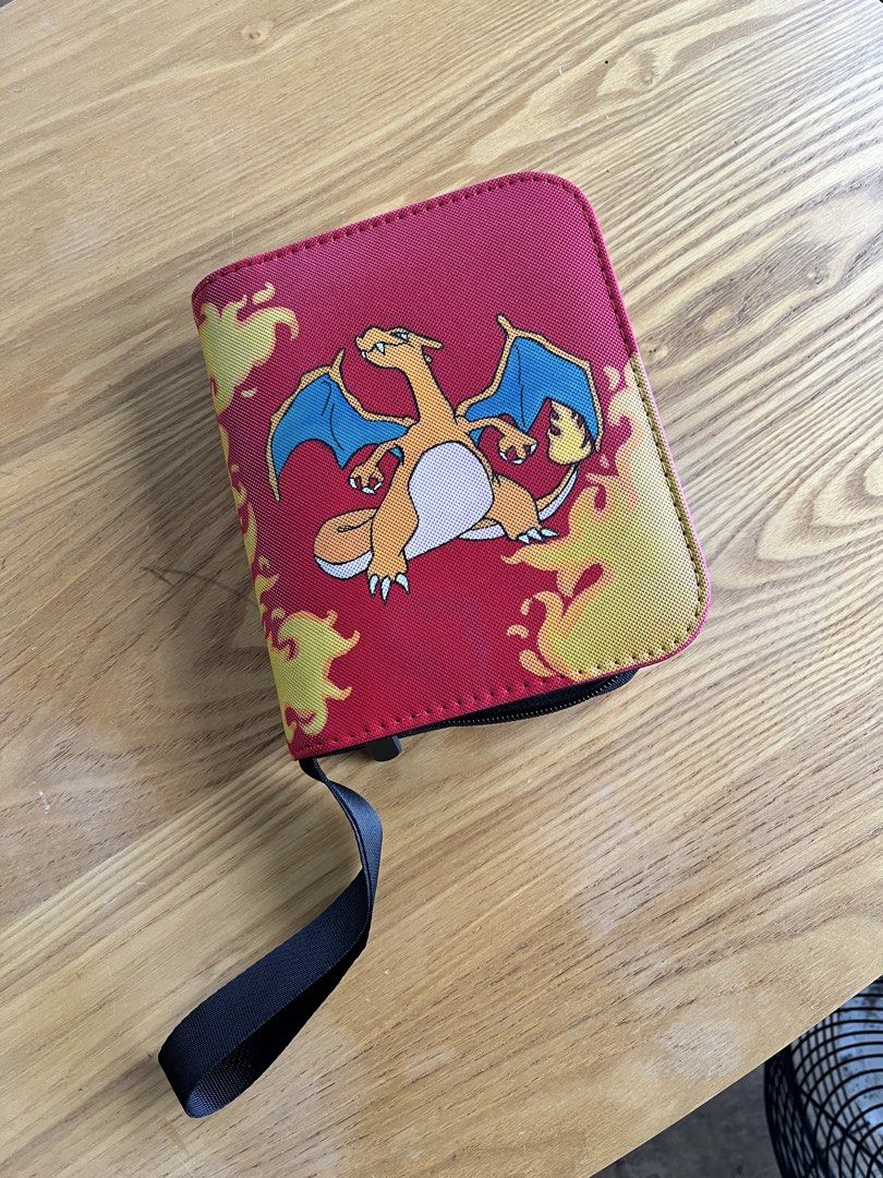 1-Pocket Pokemon Custom Painted Charizard TCG Binder (Category: Trading Cards Accessories) located in Davao. Submitted by sayiestudios (Listing ID 1460503753, Image 1). Description: - Red binder featuring a cool Charizard graphic and flames. - Secure zipper closure to keep everything safe. - Inside features clear sleeves, ideal for organizing your trading cards. - Protects your collection and keeps it looking great. - Can store top loaders - 40 p