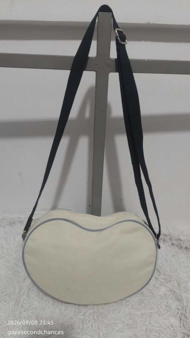 A DIDAS HEART SHAPE SLING BAG (Category: Shoulder Bags) located in Kalibo. Submitted by secondchances.thriftsh8p (Listing ID 1460480939, Image 2). Description: - Cute cream heart-shaped shoulder bag from Adidas. - Features iconic Adidas logo. - Adorned with a sequined '03' patch. - Adjustable strap for comfortable wear. - Versatile for everyday use or as a stylish accessory. - Unique and eye-catching design..