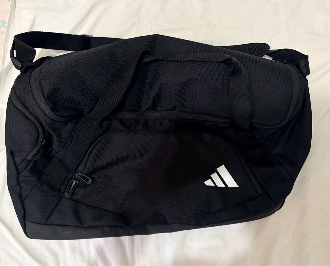 Adidas Duffle Bag 50L (Category: Sling Bags) located in Taguig. Submitted by denpaz (Listing ID 1460312941, Image 2). Description: Adidas Duffle Bag 50L Details from website: Dimensions: 28.5 cm x 64.5 cm × 27.5 cm • Volume: 58.5 L • 100% polyester (recycled) • Front zip pocket and inner slip-in pocket • External shoe compartment • Laundry pocket on back • Dual carry handles with grip • Adjustable shoulder strap • Product colour: Black • Product 