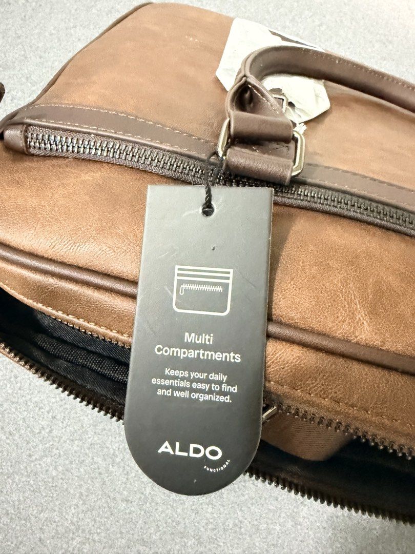 ALDO Functional Brown Faux Leather Briefcase (Category: Briefcases) located in Taguig. Submitted by kallee_fhai (Listing ID 1460305283, Image 3). Description: BRANDNEW. Never been used - Brand: ALDO - Material: Brown faux leather - Features: Multi-compartments for organization - Handles: Top handles - Strap: Detachable shoulder strap - Closure: Zip open main compartment - Style: Clean and classic design - Ideal for: Work or travel.