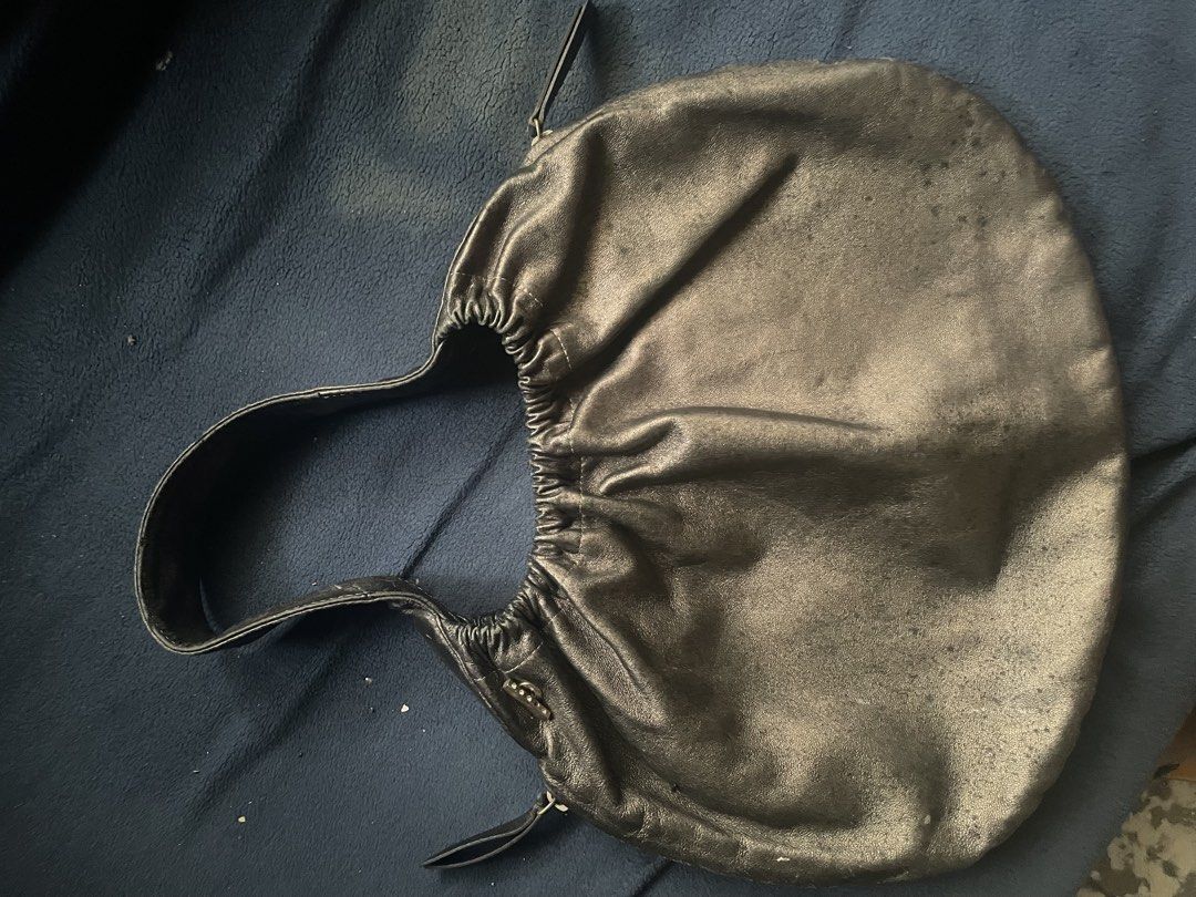 Anteprima Dark Gray Leather Drawstring Handbag (Category: Shoulder Bags) located in Caloocan City. Submitted by hardestea2026 (Listing ID 1460331052, Image 1). Description: - Stylish black leather drawstring handbag - Features a subtle metallic sheen on the leather - Single shoulder strap for comfortable carrying - Interior lined with tan fabric - Secure drawstring closure - Note: Small mark on leather, clearly shown in the second photo.
