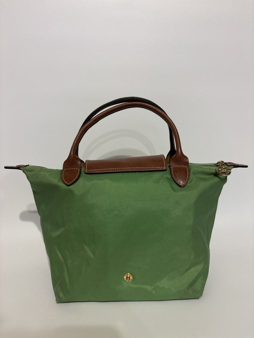 Authentic Longchamp Le Pliage Green Top Handle Bag (Category: Luxury Bags & Wallets) located in Subic. Submitted by dear.jeveaph (Listing ID 1460425995, Image 2). Description: - Authentic Green Longchamp Le Pliage Bag Small - Top Handle Style - Genuine Leather Trim and Handles - Secure Zipper Closure with Snap Button Flap - Elegant Gold Hardware Details - Ideal for Everyday Use - Compact and Lightweight Design - Needs wash!! - Tears inside the ba