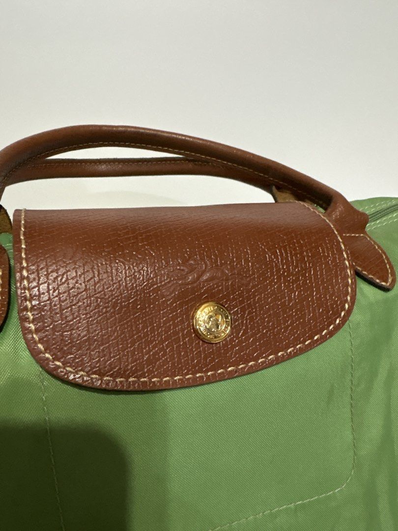 Authentic Longchamp Le Pliage Green Top Handle Bag (Category: Luxury Bags & Wallets) located in Subic. Submitted by dear.jeveaph (Listing ID 1460425995, Image 3). Description: - Authentic Green Longchamp Le Pliage Bag Small - Top Handle Style - Genuine Leather Trim and Handles - Secure Zipper Closure with Snap Button Flap - Elegant Gold Hardware Details - Ideal for Everyday Use - Compact and Lightweight Design - Needs wash!! - Tears inside the ba