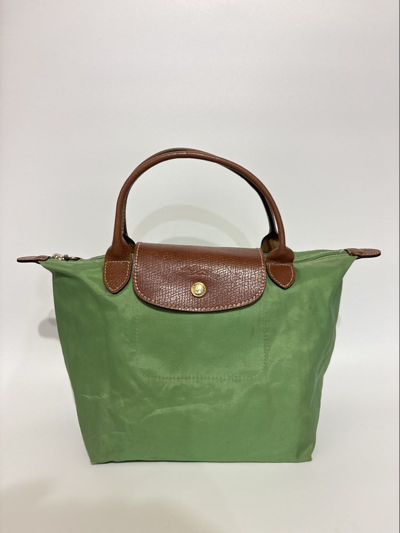 Authentic Longchamp Le Pliage Green Top Handle Bag (Category: Luxury Bags & Wallets) located in Subic. Submitted by dear.jeveaph (Listing ID 1460425995, Image 1). Description: - Authentic Green Longchamp Le Pliage Bag Small - Top Handle Style - Genuine Leather Trim and Handles - Secure Zipper Closure with Snap Button Flap - Elegant Gold Hardware Details - Ideal for Everyday Use - Compact and Lightweight Design - Needs wash!! - Tears inside the ba