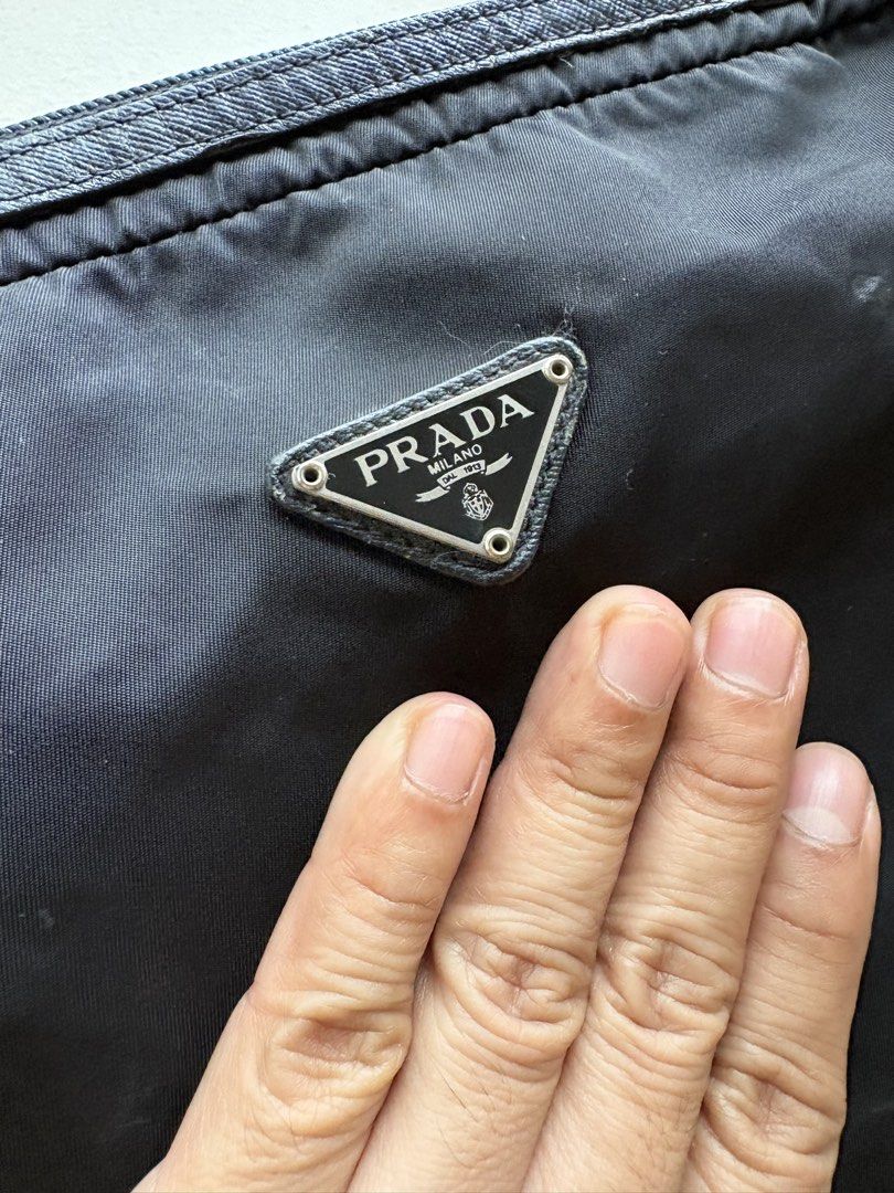Authentic Prada Nylon All-Purpose Pouch (Category: Luxury Bags & Wallets) located in Mandaluyong City. Submitted by wear_your_style (Listing ID 1460330638, Image 3). Description: Bought preloved in Japan years ago. Malaki to: approx 8 inches long and 12 inches wide. Super dami mong malagay. Perfect when you travel. Black na black pa yan. This is not a structured pouch so low maintenance siya. Smooth zipper. Leather trims. Issues: signs of use. Yu