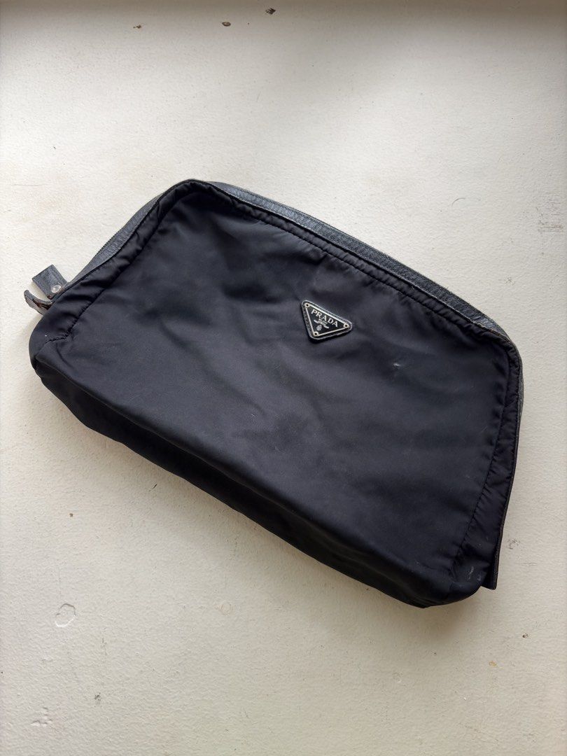 Authentic Prada Nylon All-Purpose Pouch (Category: Luxury Bags & Wallets) located in Mandaluyong City. Submitted by wear_your_style (Listing ID 1460330638, Image 1). Description: Bought preloved in Japan years ago. Malaki to: approx 8 inches long and 12 inches wide. Super dami mong malagay. Perfect when you travel. Black na black pa yan. This is not a structured pouch so low maintenance siya. Smooth zipper. Leather trims. Issues: signs of use. Yu